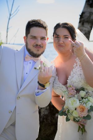 Les nouveaux mariés montrent fièrement leurs alliances sur la plage de l'Auberge des Îles à Saint-Gédéon.
