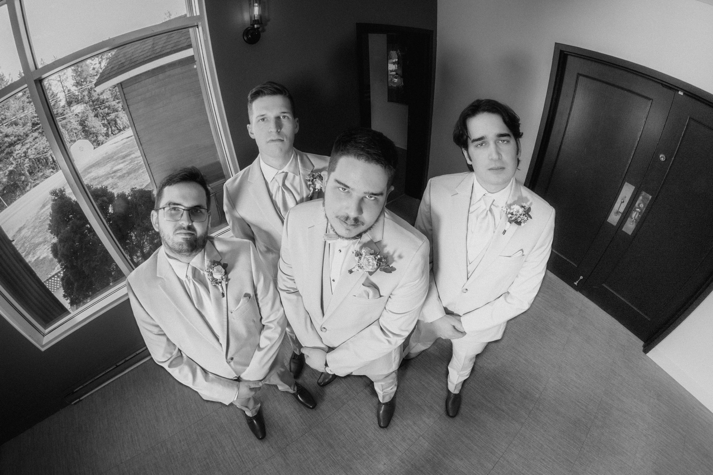 Photo en noir et blanc effet fisheye des garçons d’honneur au style d'un album de groupe des années 90.