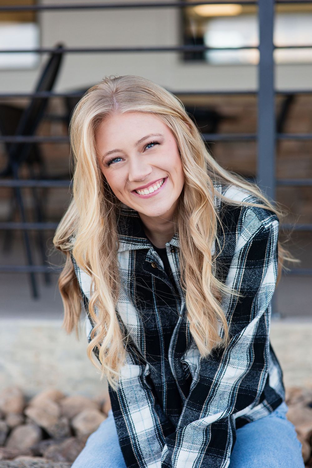 High school senior portrait sitting on a rock wall