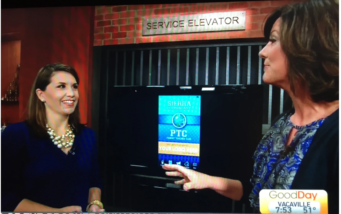 Two women conversing near a service elevator on a Good Day Vacaville morning show set at 7:53 AM.