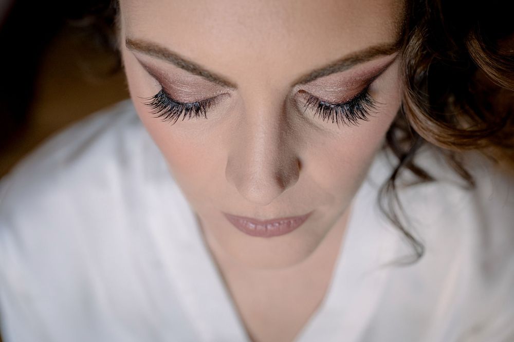 Close-up portrait of bride with elegant eye makeup and long lashes on wedding day.