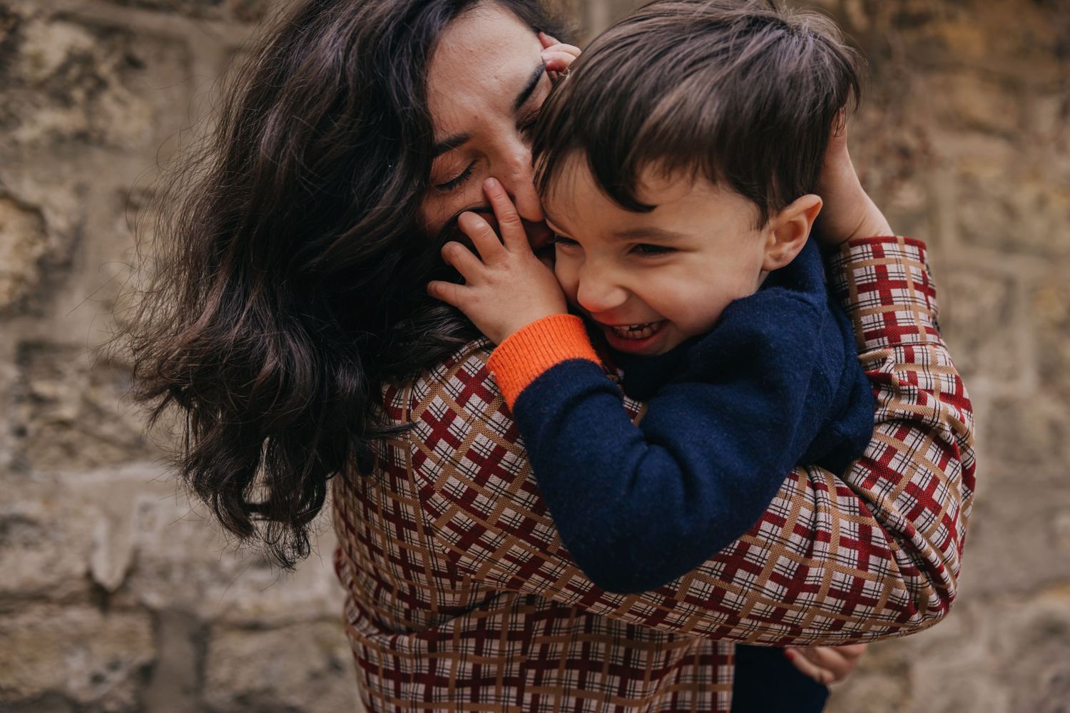 Une maman fait des bisous prout à son fils pendant une séance photo, ce qui le fait rire aux éclats