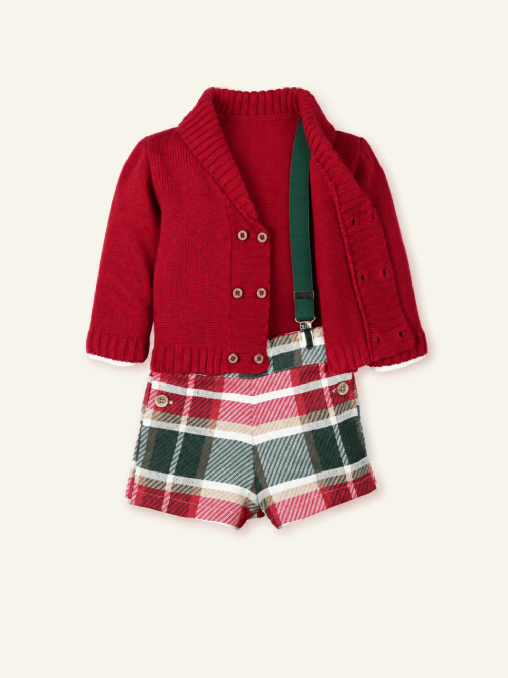 Red knit cardigan paired with plaid shorts and green suspenders, a festive holiday outfit for baby boys.