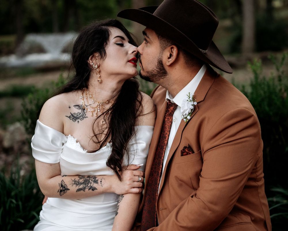 A romantic couple in wedding attire share intimate moments in an outdoor garden setting.