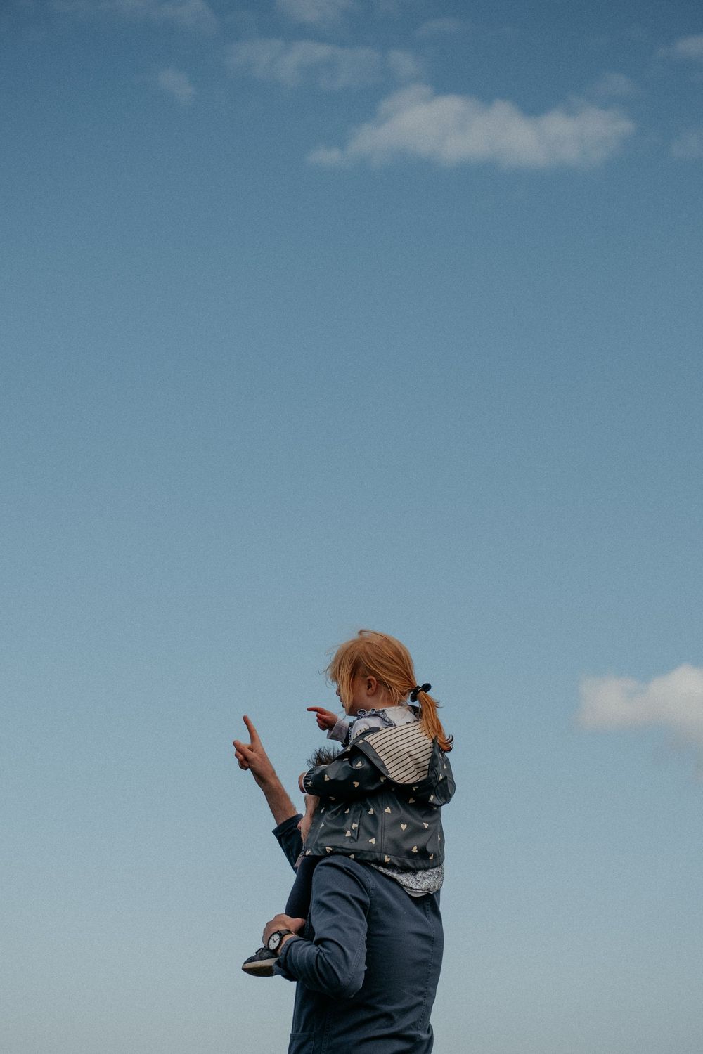 Dad with child on shoulders at family session at St Marys lighthouse Northumberland