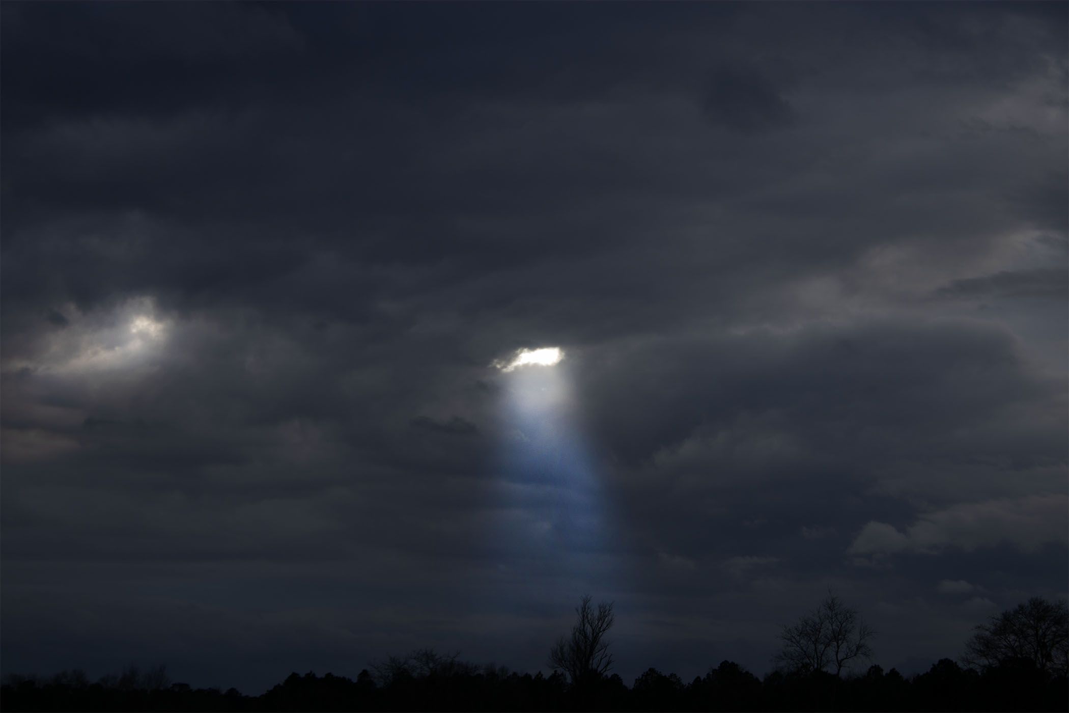 The sun shining through clouds.