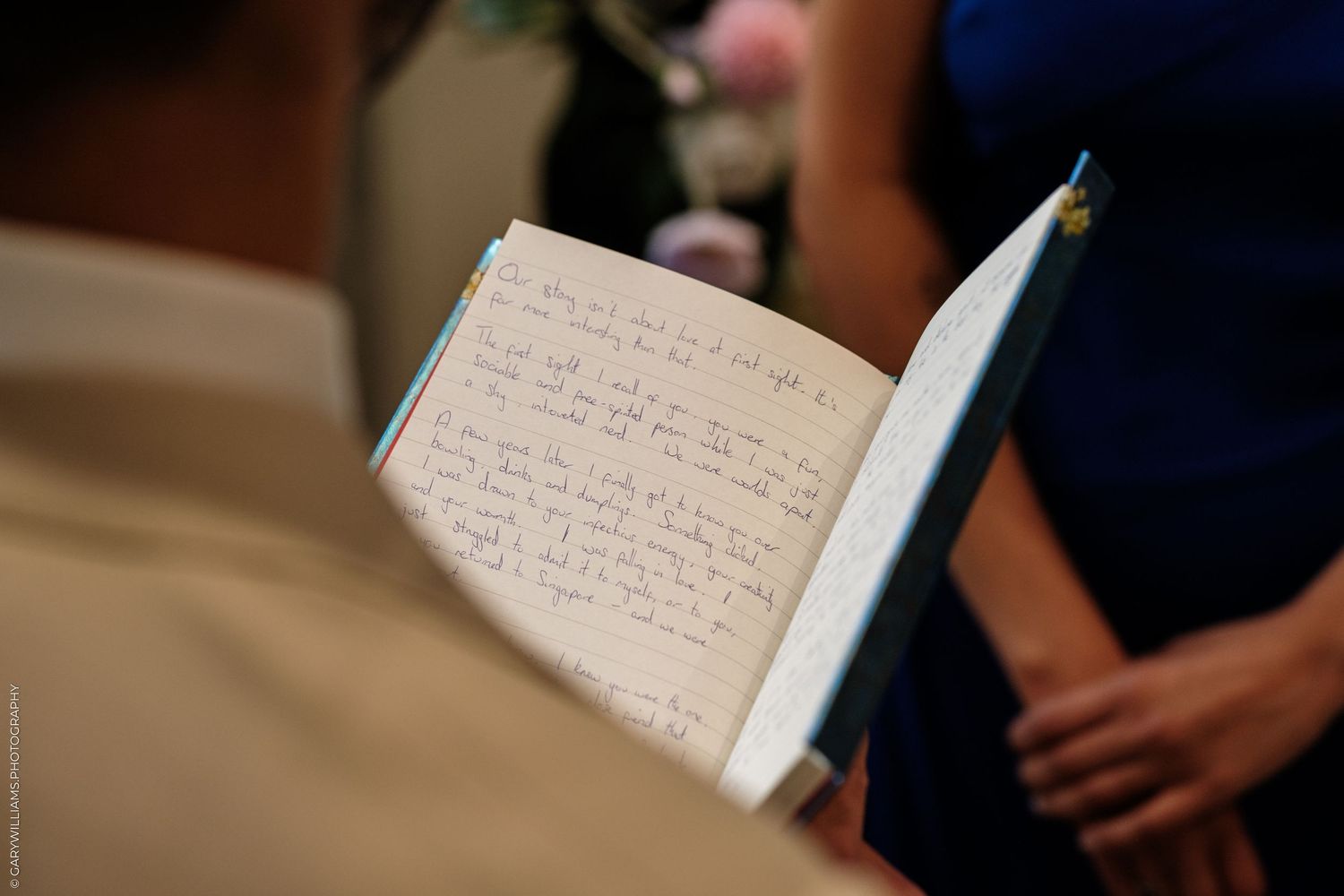 Open wedding guest book with handwritten messages displayed at a reception ceremony.