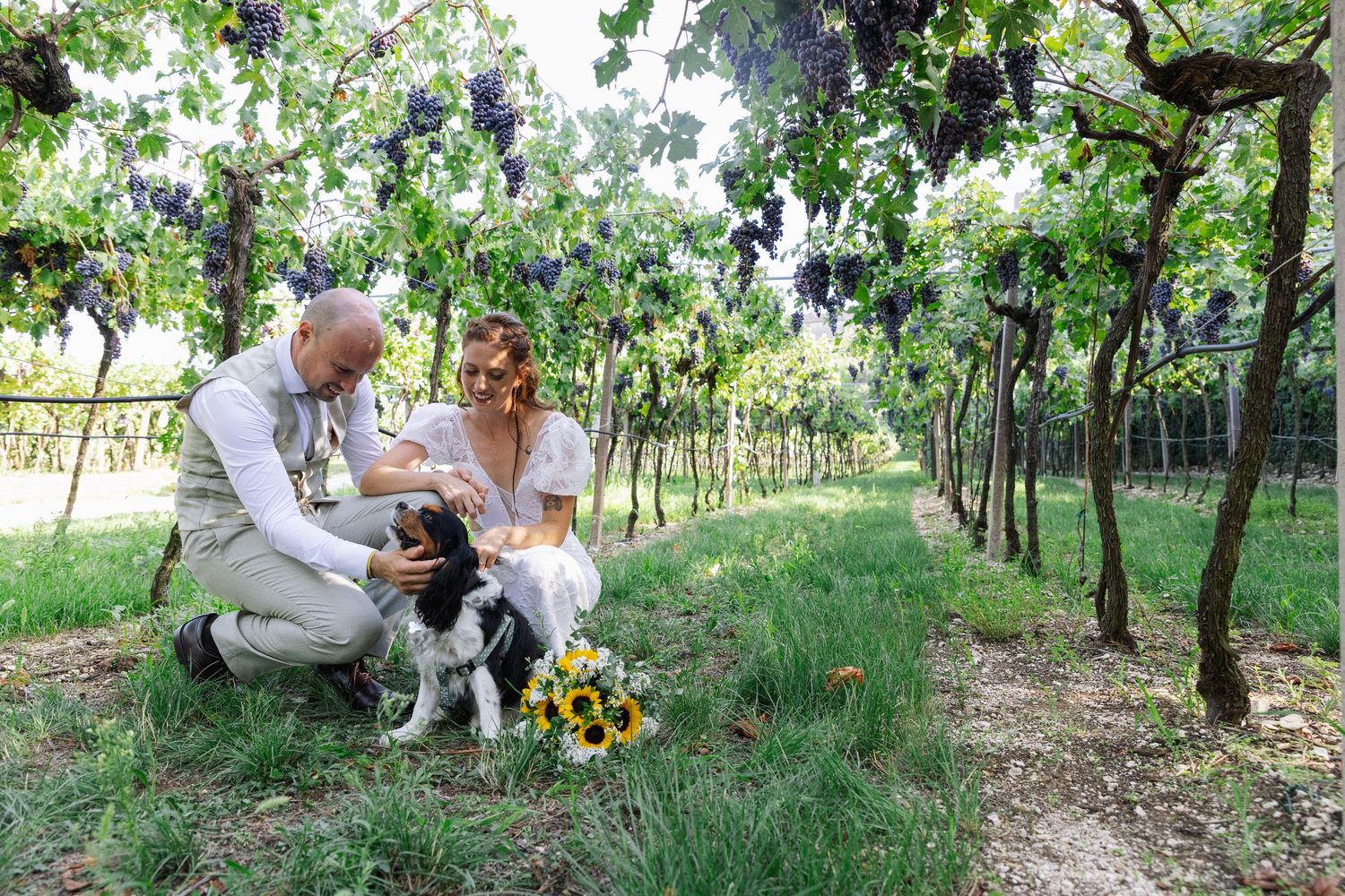 Sposi seduti sull’erba durante un momento rilassato del matrimonio