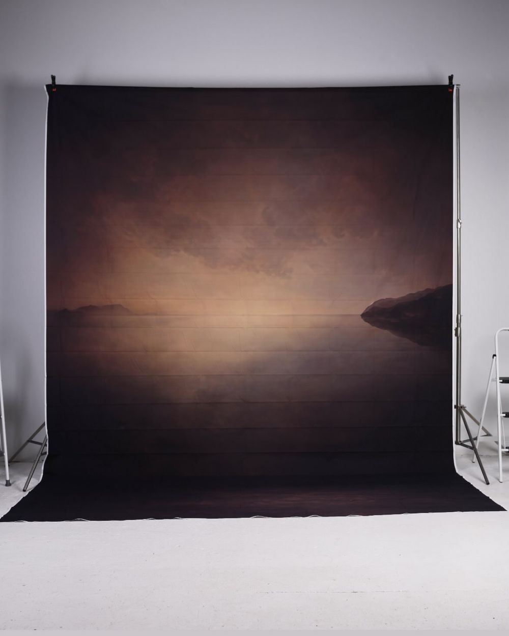 Dark moody lake landscape photography backdrop with glowing horizon on a stand.