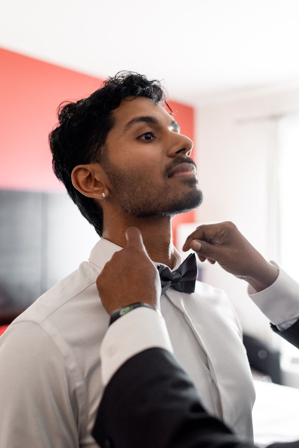 father of the groom putting bow tie on the groom