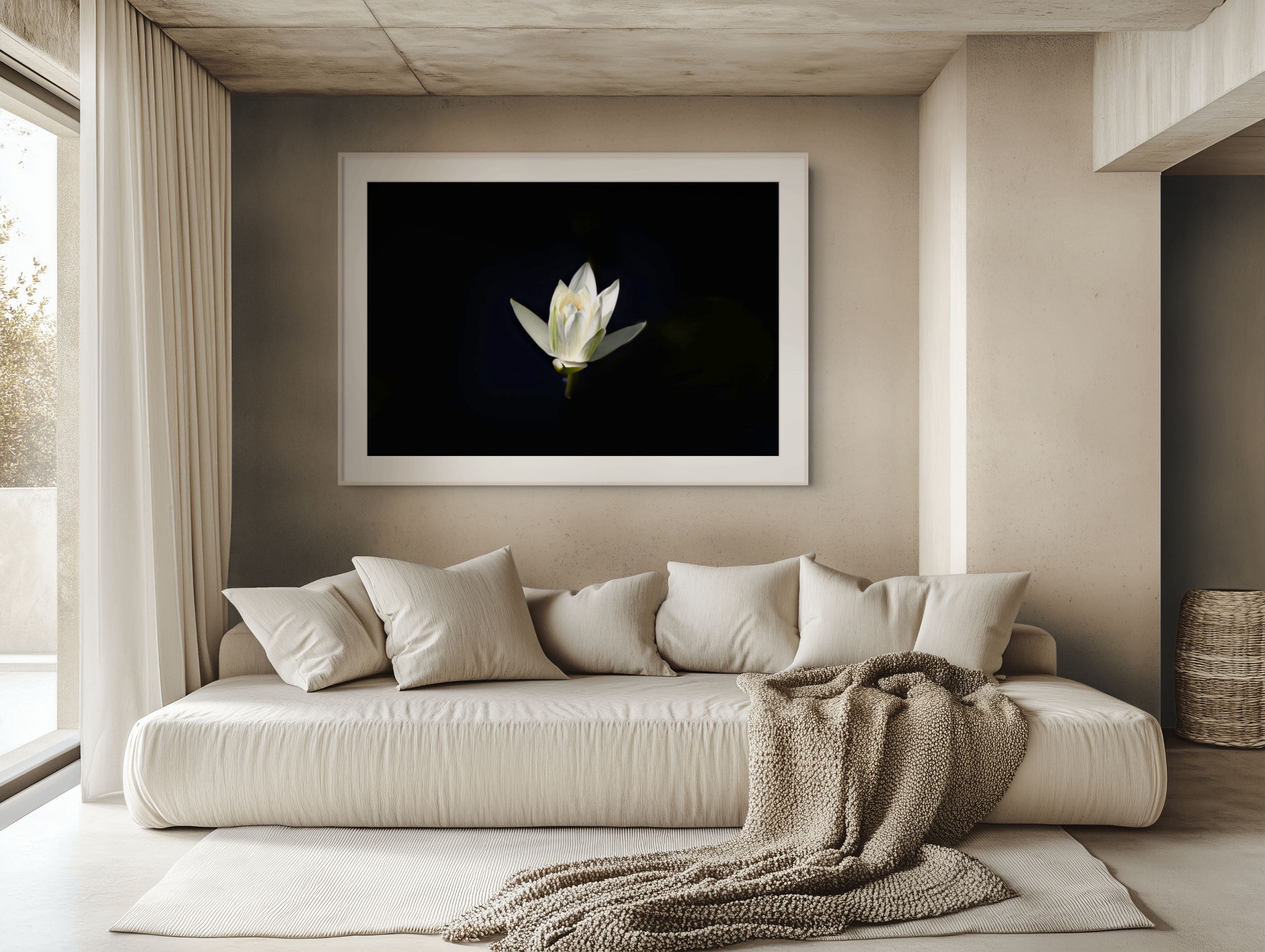 Minimalist bedroom with beige sofa and framed white lotus flower art on dark background above neutral linen cushions.