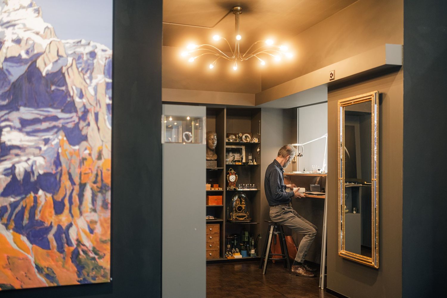 Modern office interior with large mountain artwork and person working at desk.