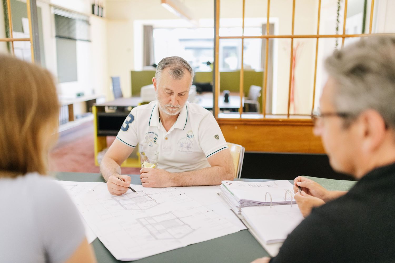 Colleagues reviewing architectural plans during a professional consultation.