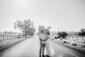 wedding couple on road with sun behind them