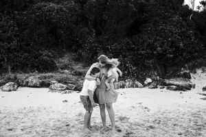 mum and children cuddling on the beach