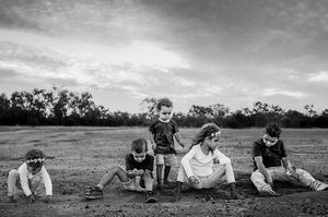 Indigenous children playing in red dirt Longreach