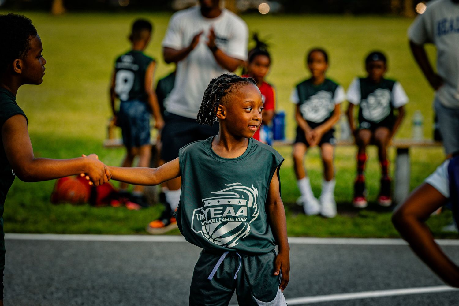 A young athlete in a team jersey focuses during a basketball game.