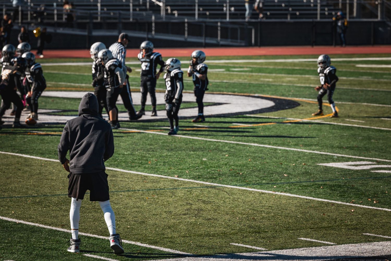 Players spread across football field during practice session.