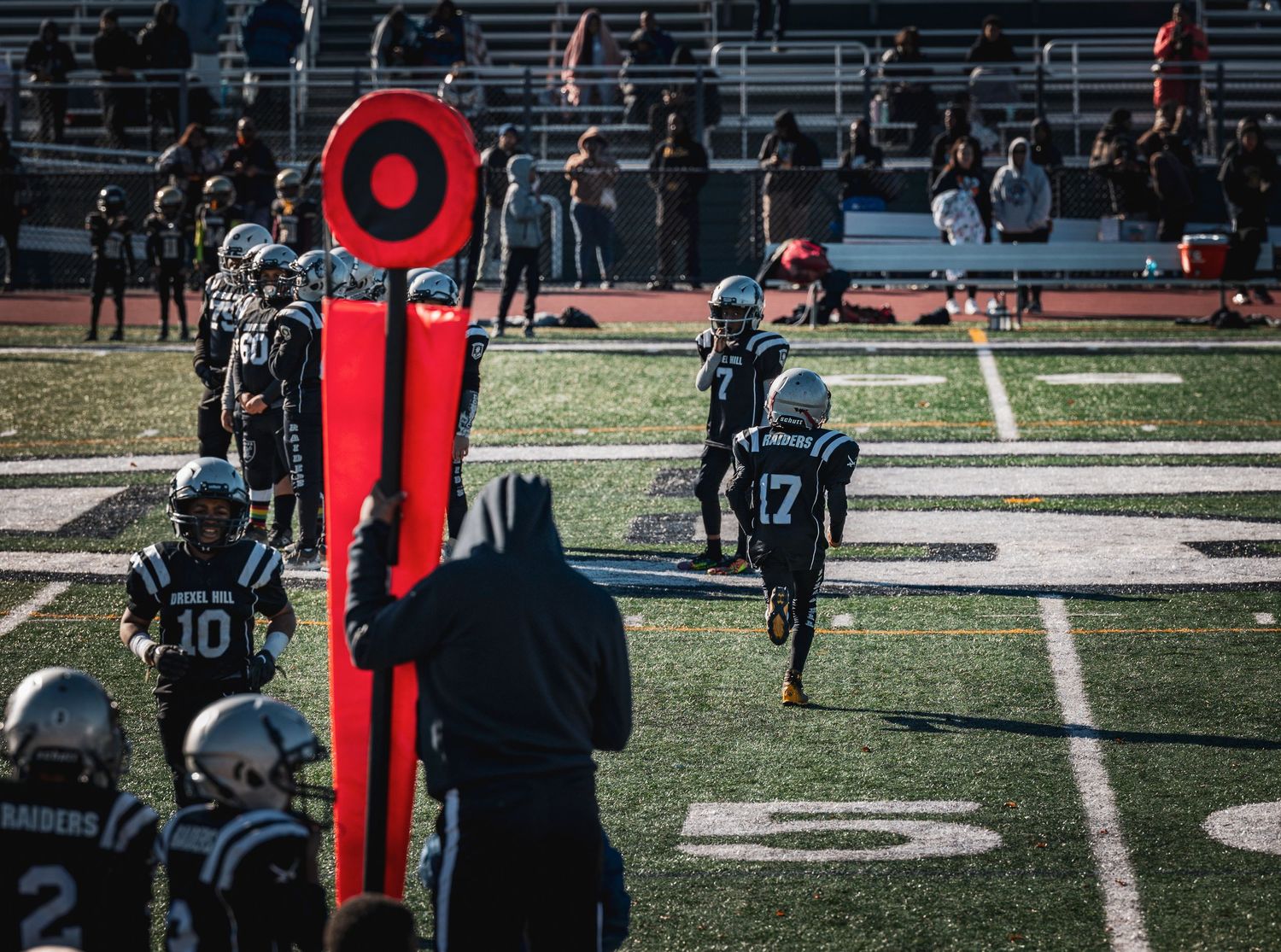 Players and referees positioned across football field during game play.