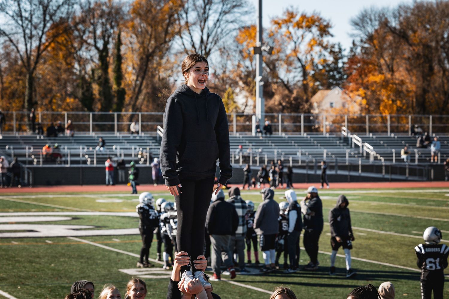Fall foliage surrounds sports field where athletes gather for practice.
