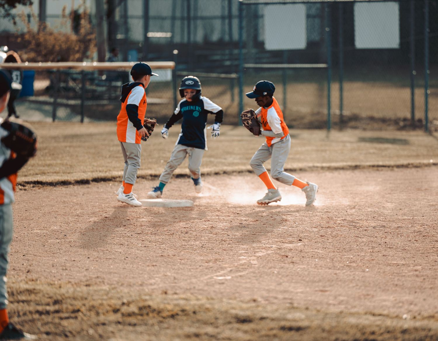 Players running and playing on a dusty baseball field during a game or practice session.