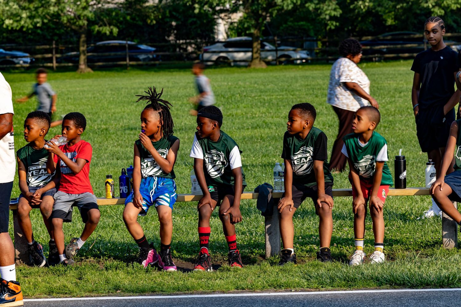 Athletes lined up on grass during an outdoor basketball activity.