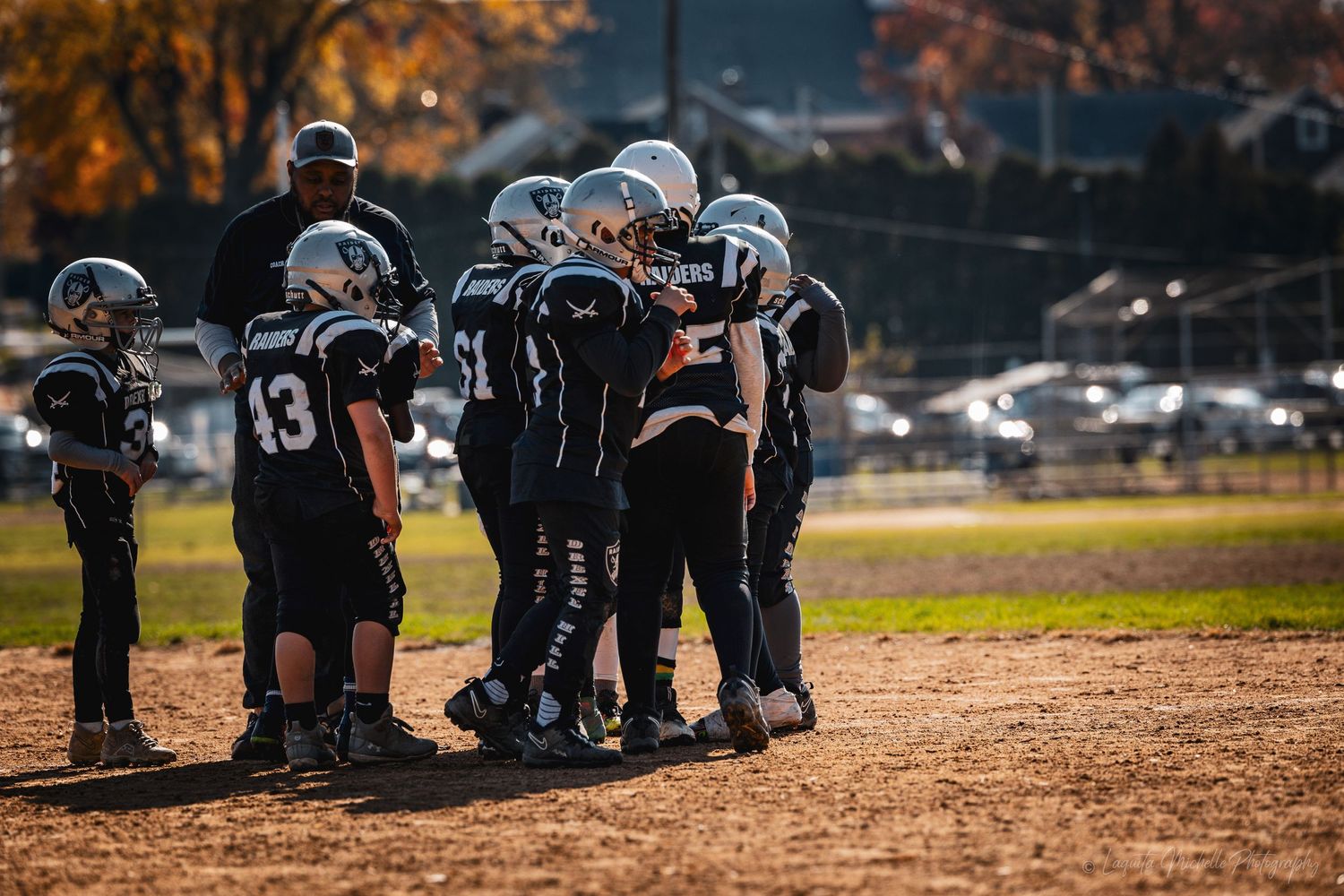 Team members lined up on the football field during a fall practice session.