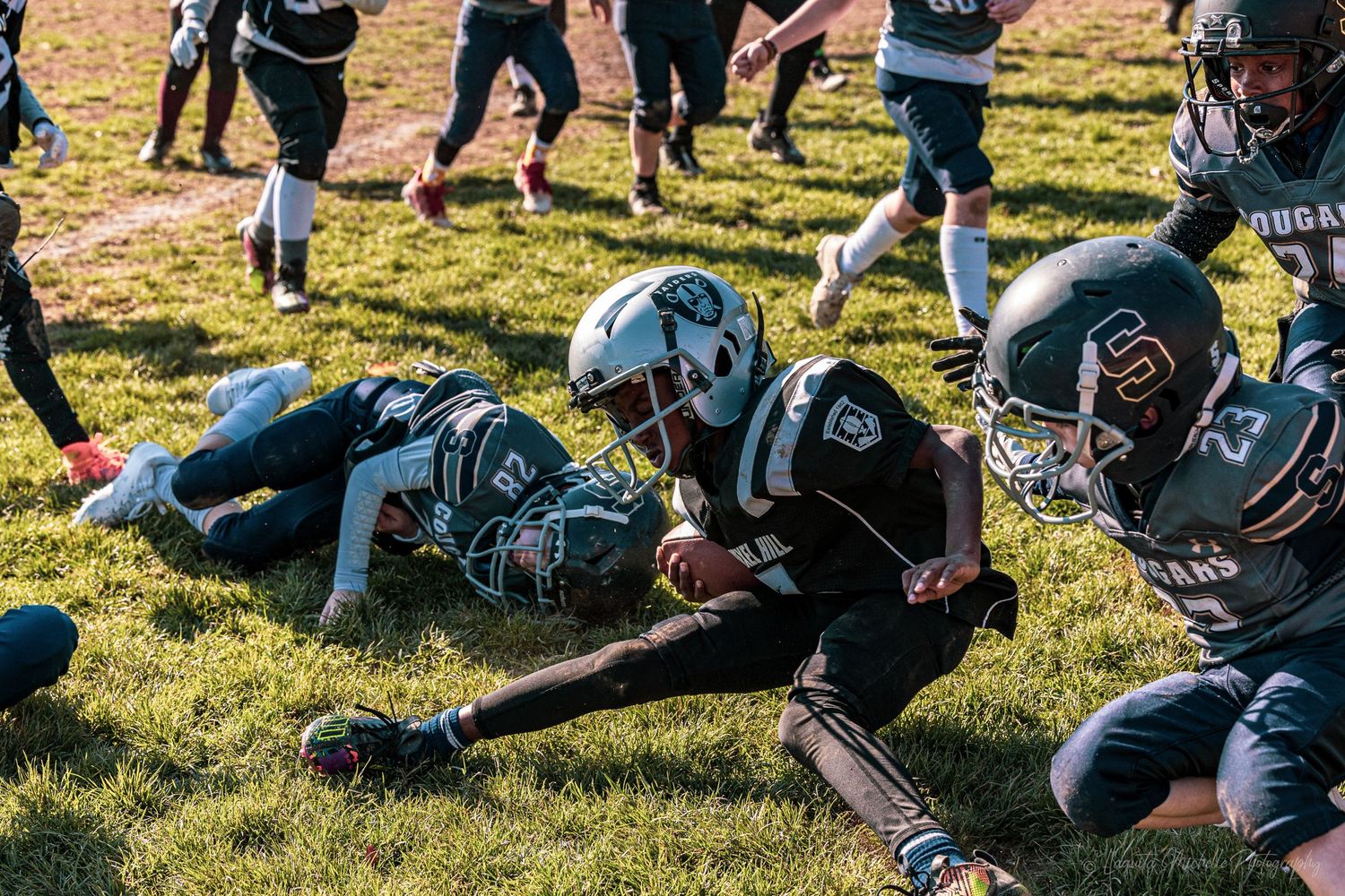 Players doing warmup exercises on a grassy field during an autumn football practice.