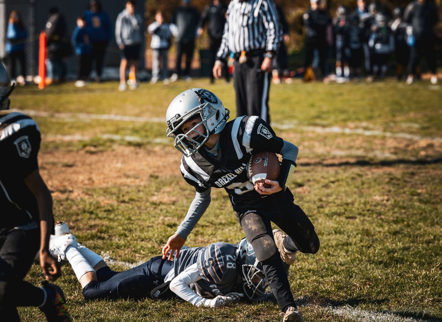 Football players in protective gear practicing on grass field during training session.