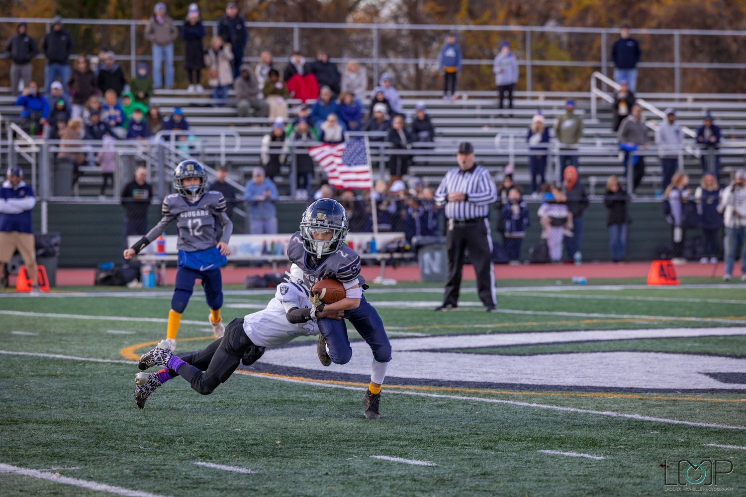 American football game action shot on artificial turf with players in mid-play.