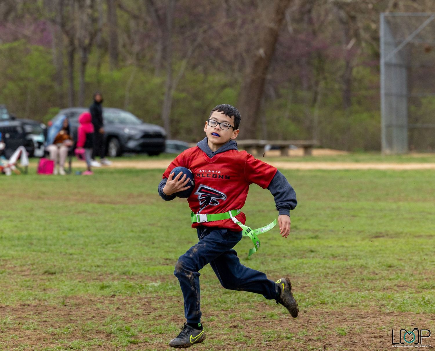 A sequence of action shots shows someone diving to catch a football in a grassy field during recreational play.