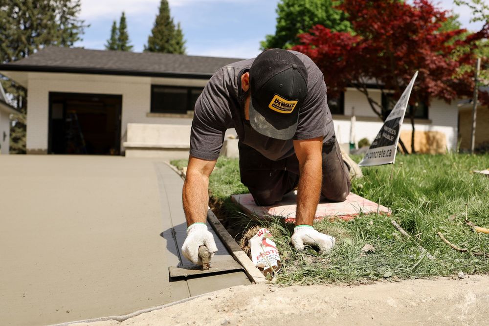 Person in gloves installs artificial turf sections in a backyard landscaping project.