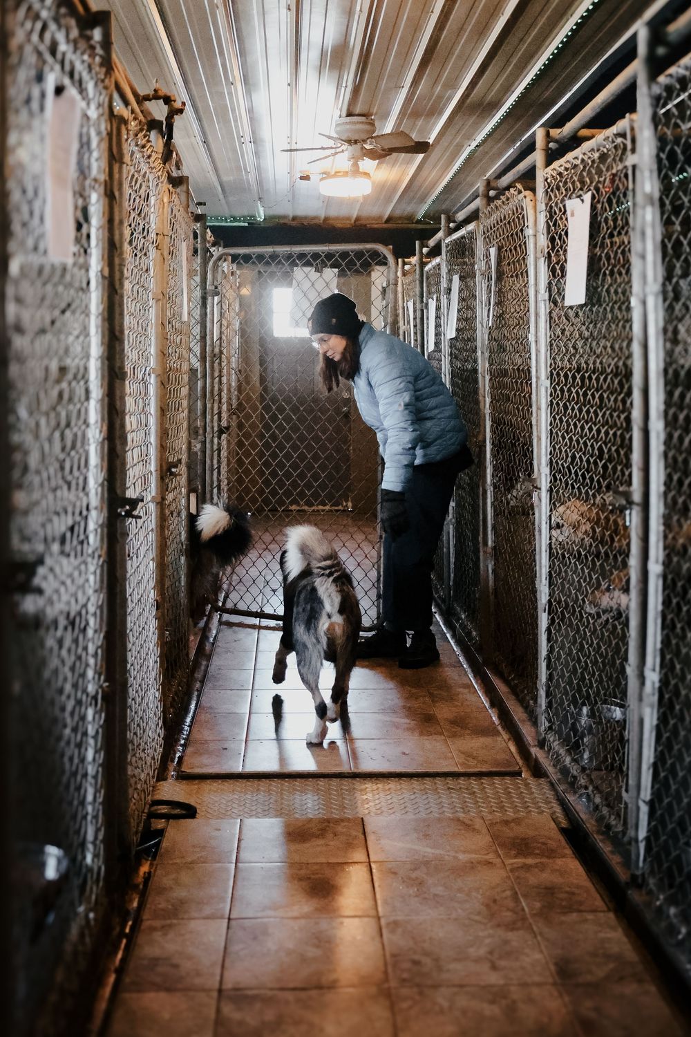 Sequence of photos showing someone moving through a long industrial hallway with wire mesh walls.