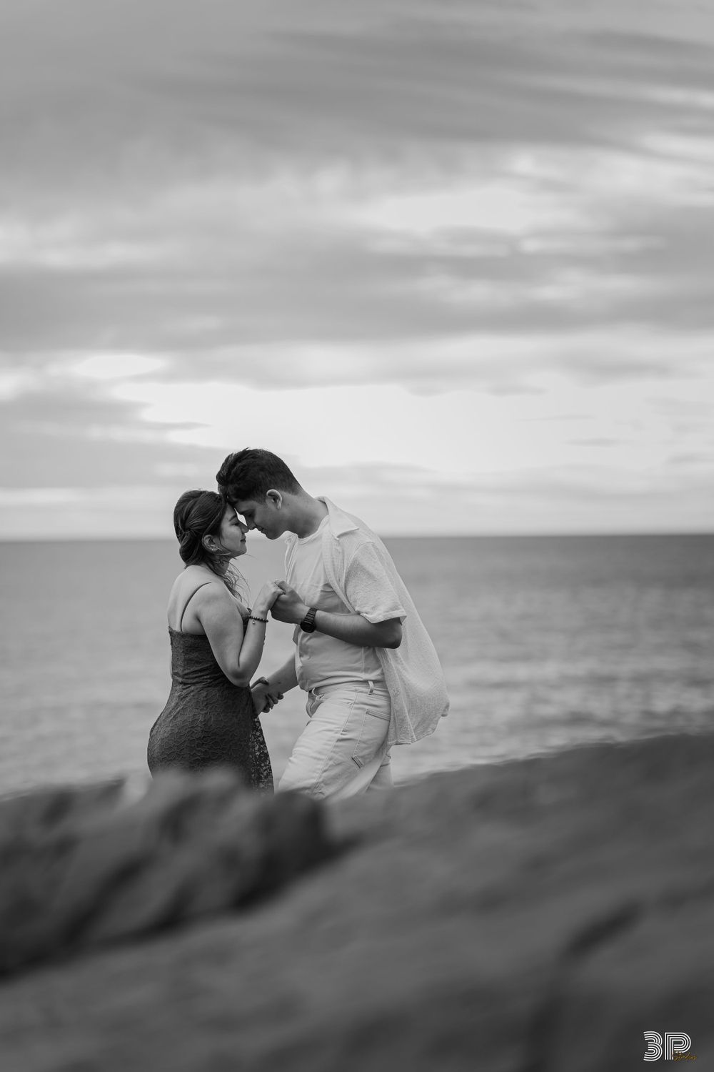 Engaged couple laughing and having fun during a playful pre-wedding photoshoot in an outdoor setting