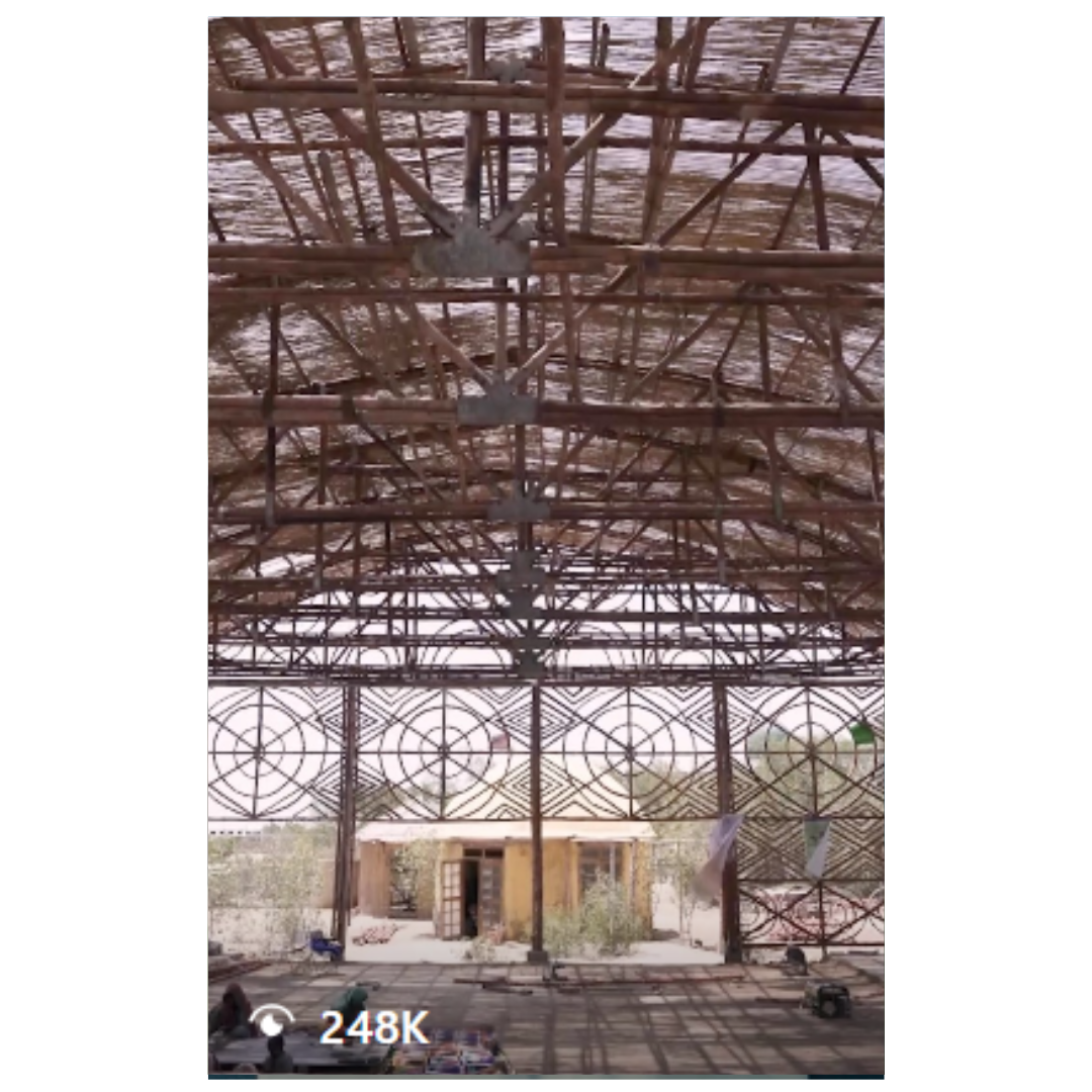 Abandoned industrial warehouse interior with rustic metal roof and exposed beams.