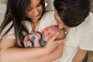 A series of intimate newborn baby photos showing parents holding and bonding with their new baby.
