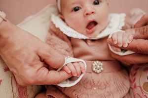 A collection of close-up images showing tiny baby hands and feet with white pearl-like decorative accents.