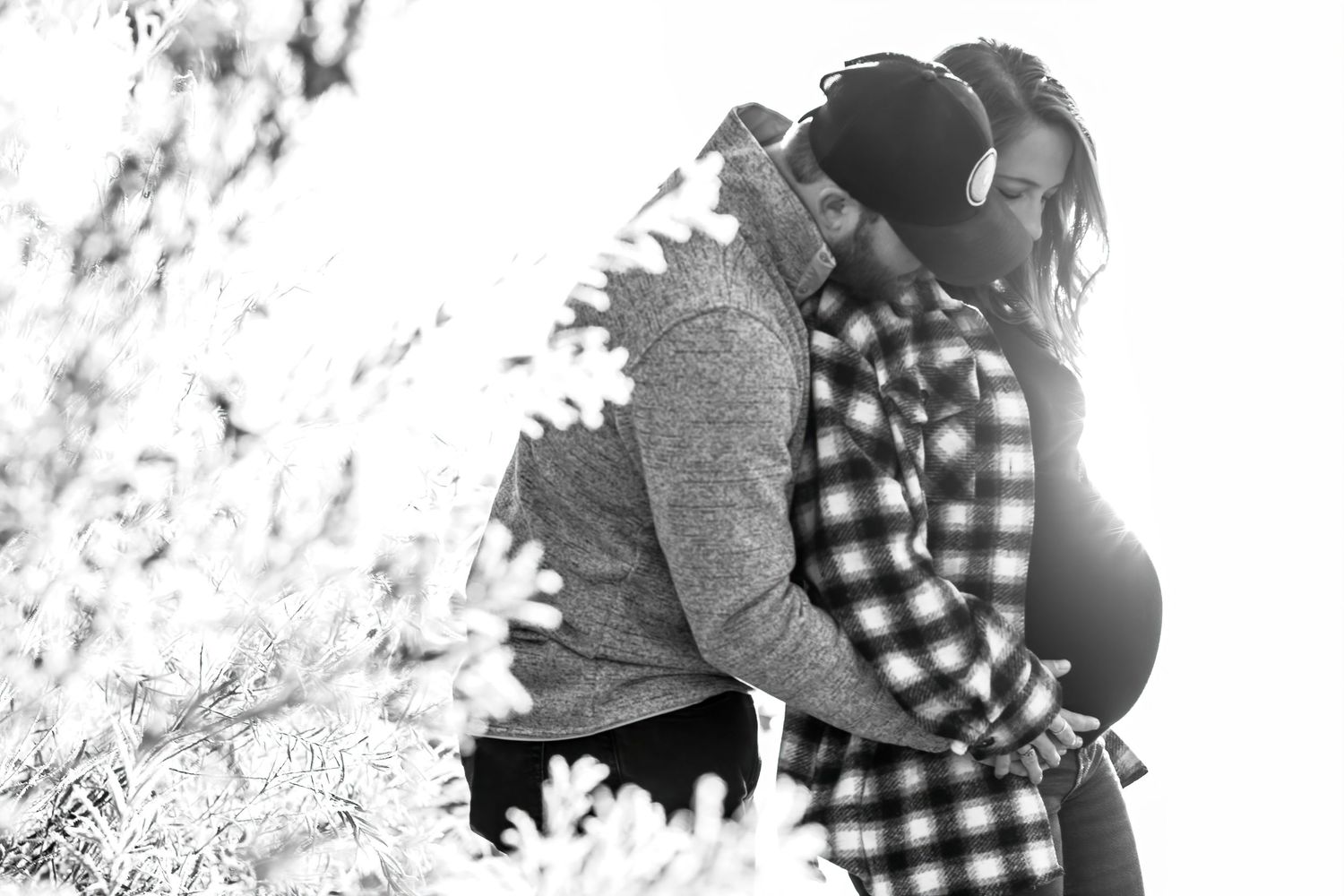 Silhouetted maternity couple sharing tender moment in bright sunlight in Tri Cities, Washington.