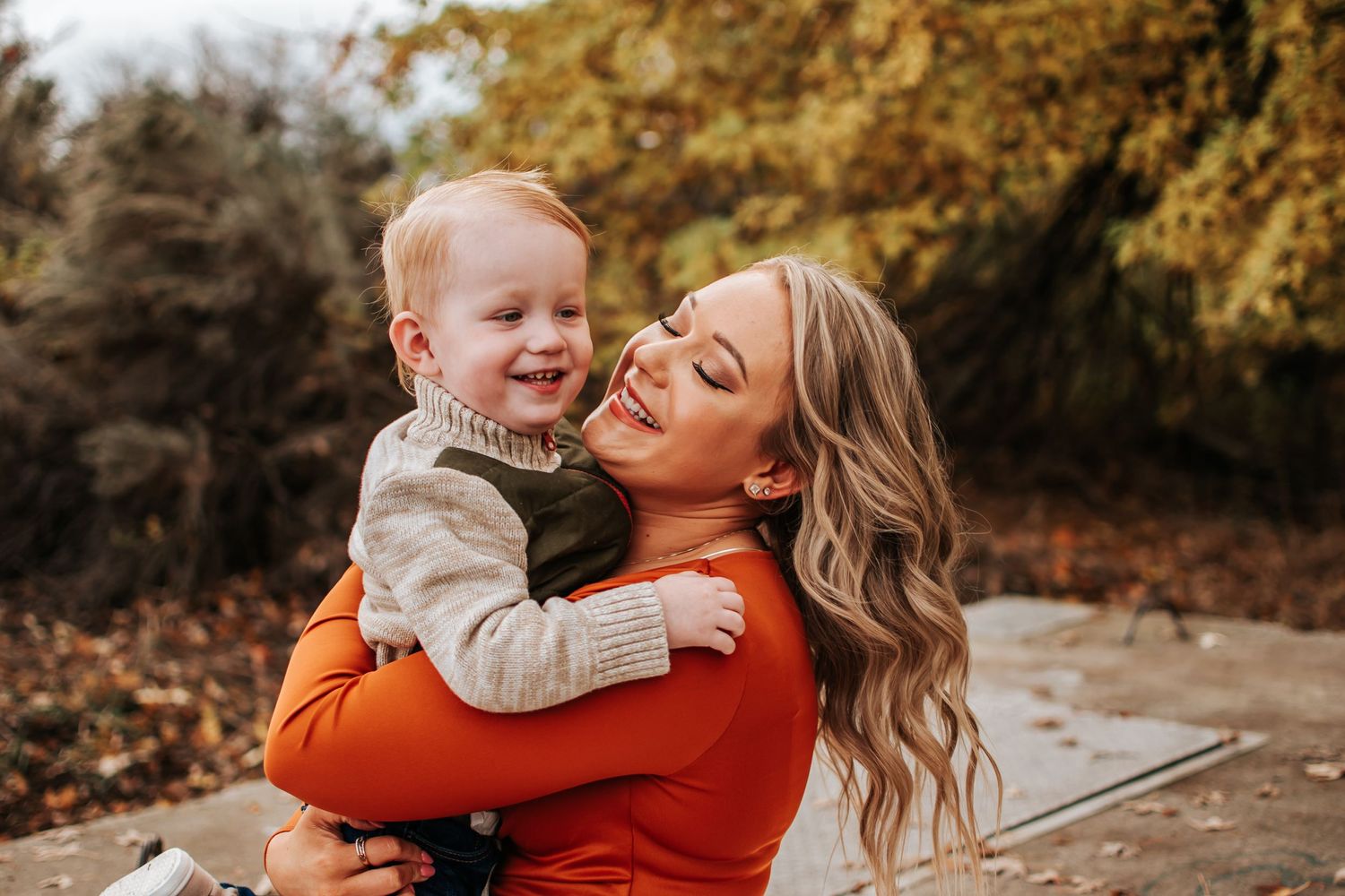 A warm fall scene capturing a tender moment between parent and child in matching orange and beige outfits in Richland, Washington.