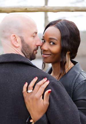 Intimate engagement photos showing couple embracing in winter clothing.