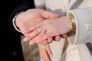 Close-up of hands wearing wedding rings and jewelry during engagement photoshoot by Hamptons photographer.