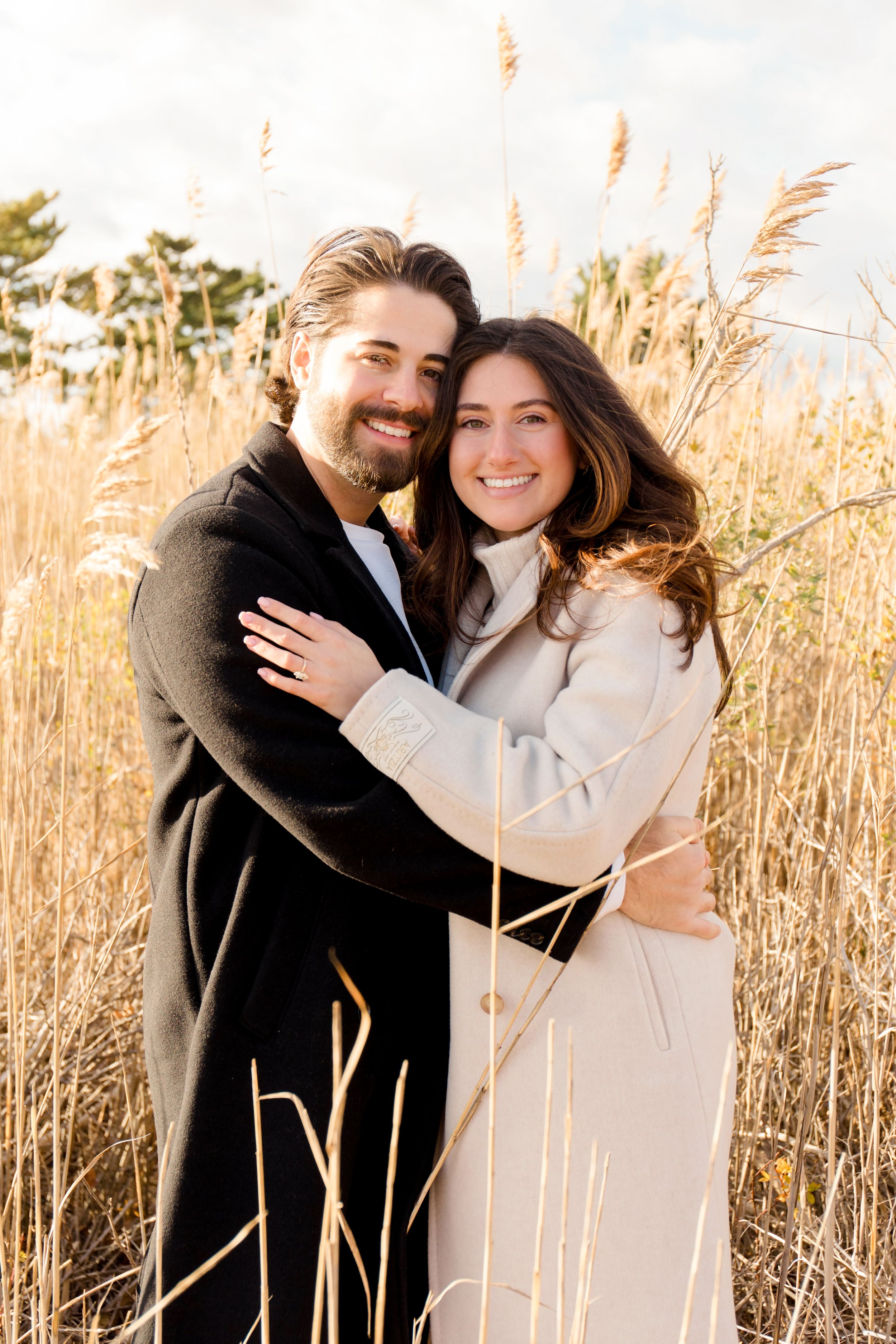 Romantic couple shares intimate moments among tall wheat grass during sunset by Hamptons photographer.