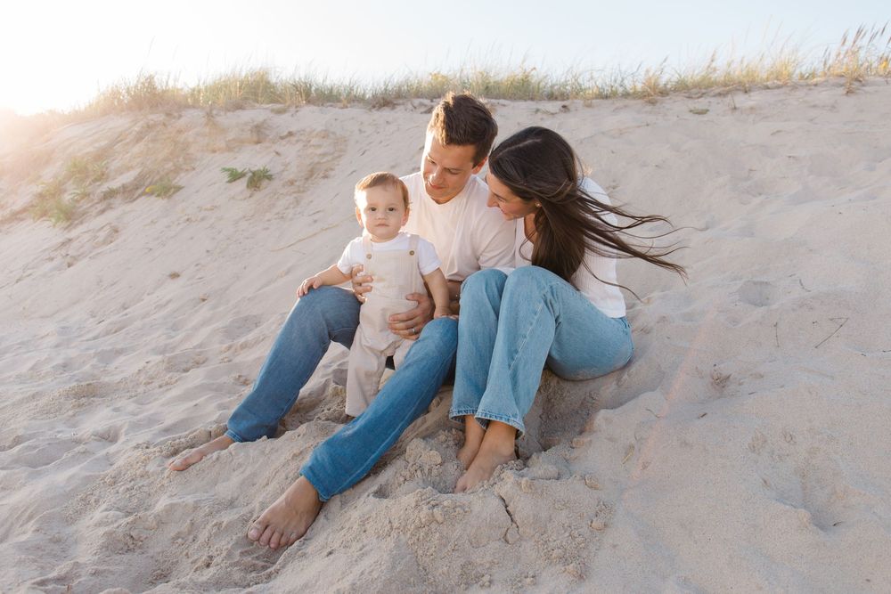 Candid beach photos showing playful family moments on sand dunes.