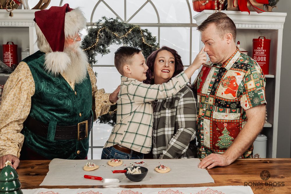 Family gathers around rustic wooden table during Christmas season with festive decorations and presents. Santa Photos Webster League City