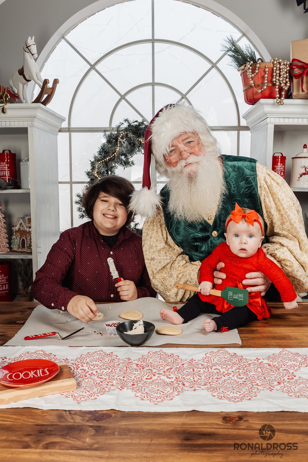 A festive holiday photo series showing a family writing letters to Santa at a wooden table with Christmas decorations. Santa Photos Webster