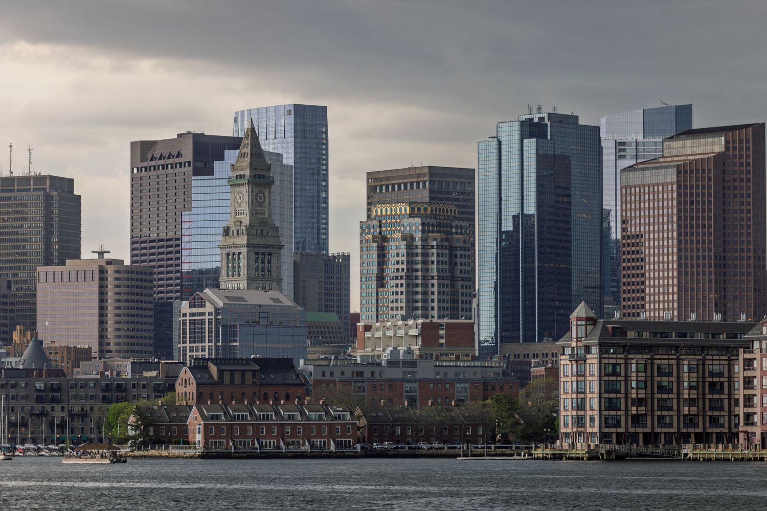 Dramatic skyline of Montreal's downtown business district with modern skyscrapers along the waterfront on an overcast day.