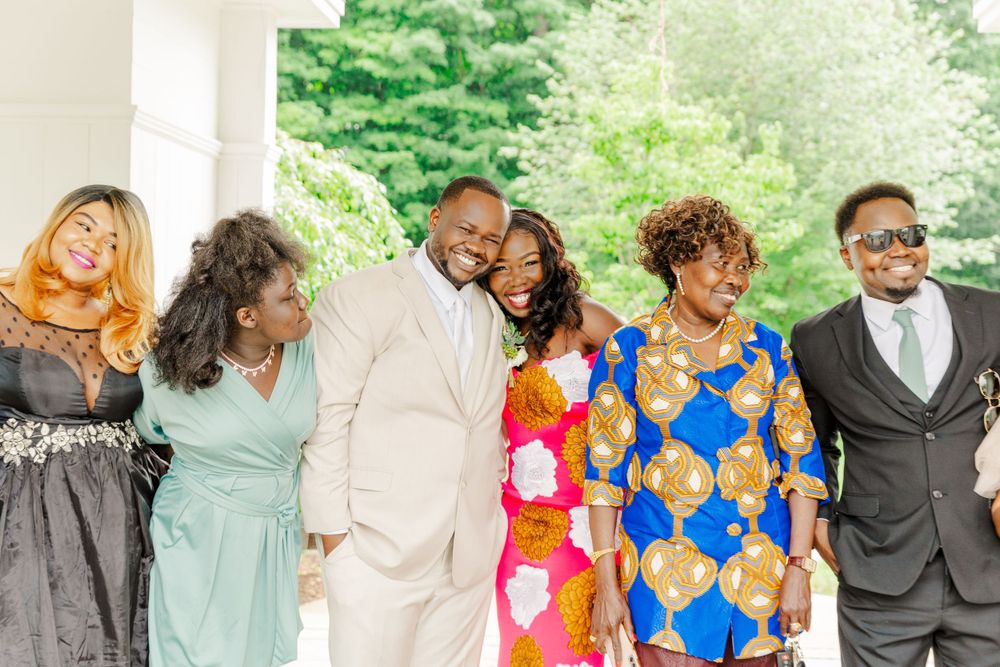 Wedding group in formal attire sharing laughs during a celebration.