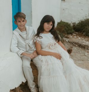 niños de comunión posando junto al mar