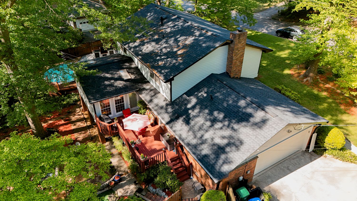 Aerial view of residential neighborhood with trees and landscaping.