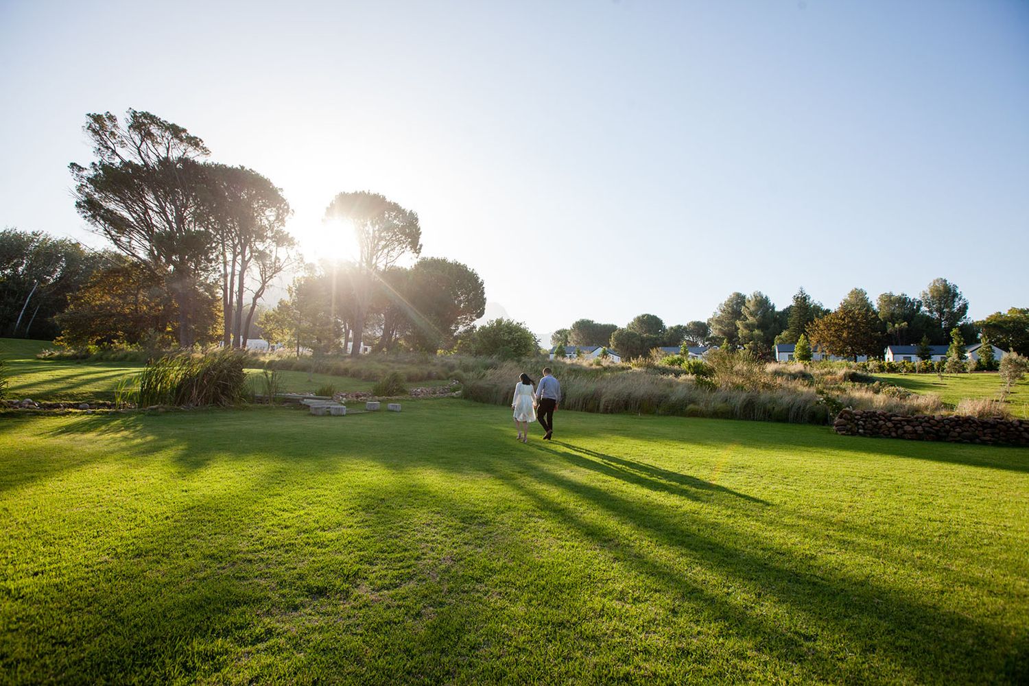 Romantic couple enjoying a sunset stroll holding hands (Couple Photoshoot captured by Lesley Marks)